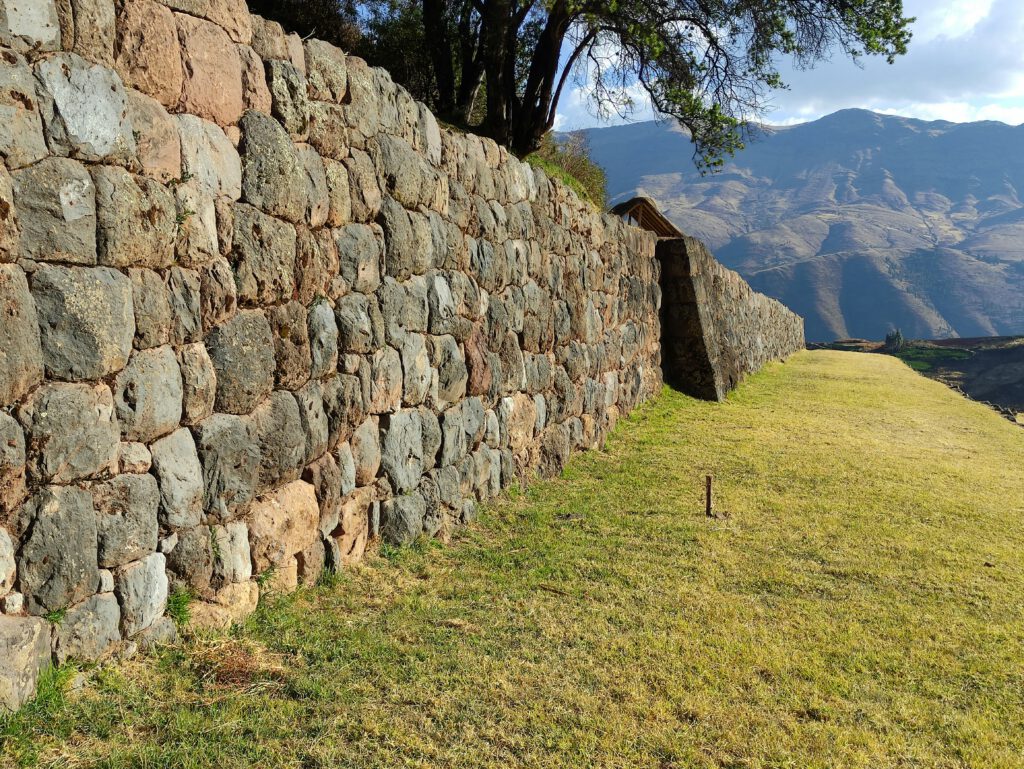 Photo by <a href="https://unsplash.com/id/@yuri_rodriguez?utm_source=unsplash&utm_medium=referral&utm_content=creditCopyText">Yuri Rodríguez Rodríguez</a> on <a href="https://unsplash.com/id/foto/dinding-batu-dengan-rumput-dan-pegunungan-di-latar-belakang-9lzmq8nHXbY?utm_source=unsplash&utm_medium=referral&utm_content=creditCopyText">Unsplash</a>
      